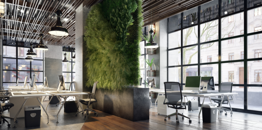Modernes Büro mit Desksharing, hell und viel Glas, aufgeräumte Schreibtische, grüne Wand als Trennung verschiedener Arbeitszonen