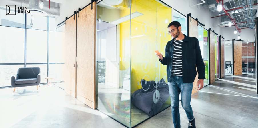 Ein Mann bucht sich einen Arbeitsplatz in einem Coworking Space