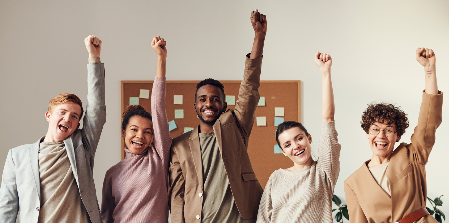 Sinnbild für 30-Stunden-Woche: fünf Büroangestellte, die sich sehr über das neue Modell freuen und ihre Hände nach oben strecken und "Yeah!" schreien.