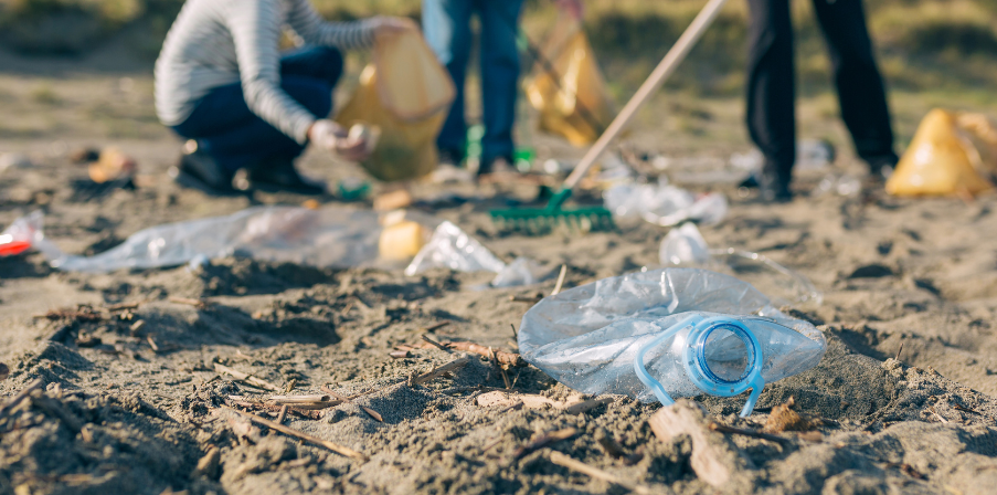 Sinnbild für Corporate Social Responsibility: Menschen sammeln Abfälle am Strand, um die Umwelt zu reinigen.